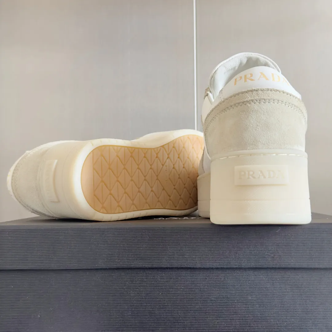 👟👟Ex-factory price 660👟👟 Top version Prada Latest Downtown Bold series Thick sole Platform shoes Triangle logo Casual sneakers White shoes Original purchase and development Production Downtown Bold sneakers are inspired by basketball shoes in the 1980s, with sporty design and exquisite details. Crafted from perforated leather, the statement platform sole provides a unique, modern style. The Prada logo is interpreted from different angles, decorated with the iconic enamel-coated triangular metal logo, highlighting the unique classic style. Exquisite packaging at the delivery counter🛍📦 ▪️Fabric: Original custom imported first-layer cowhide ▪️Inner lining: Original imported soft sheepskin ▪️Outsole: Original molded ultra-light foam material ▪️Sole thickness: 4.5CM ▪️Size: Women's 35-40